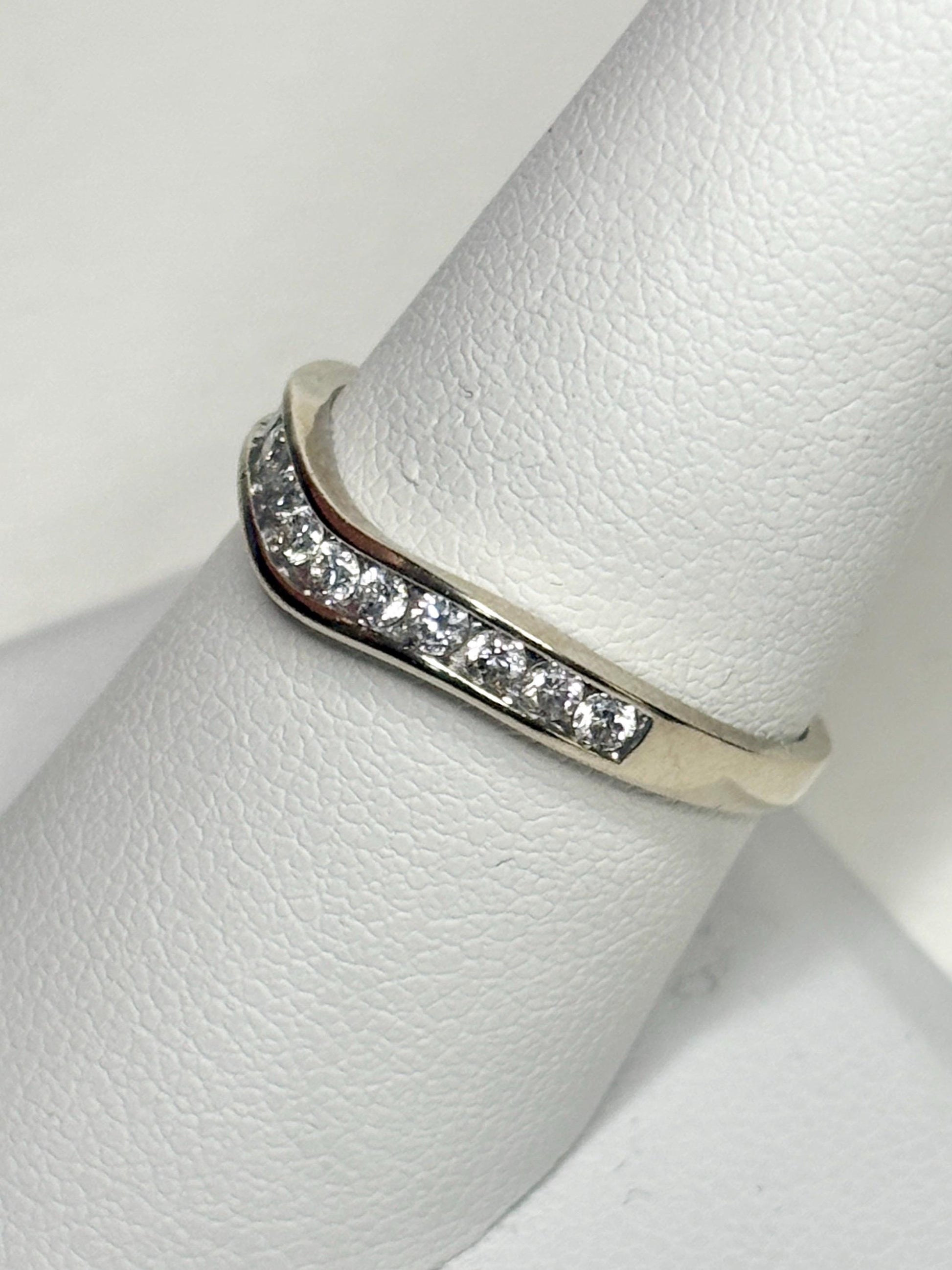 Contoured 14k white gold wedding band with channel-set diamonds.