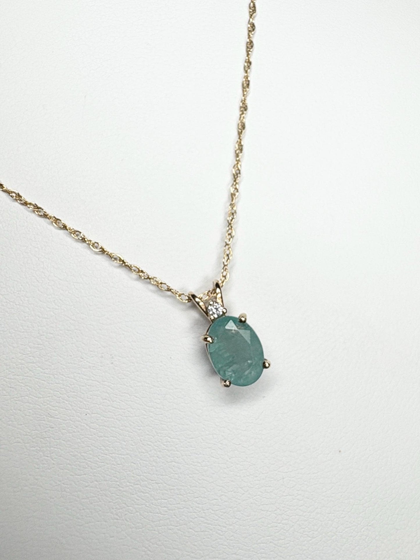 14k yellow gold necklace with oval grandidierite and diamond pendant.