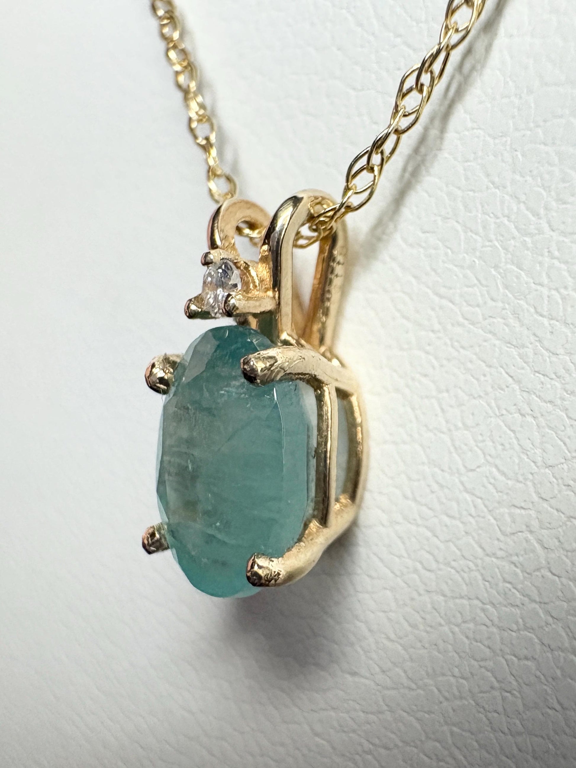14k gold pendant necklace with oval grandidierite and diamond.