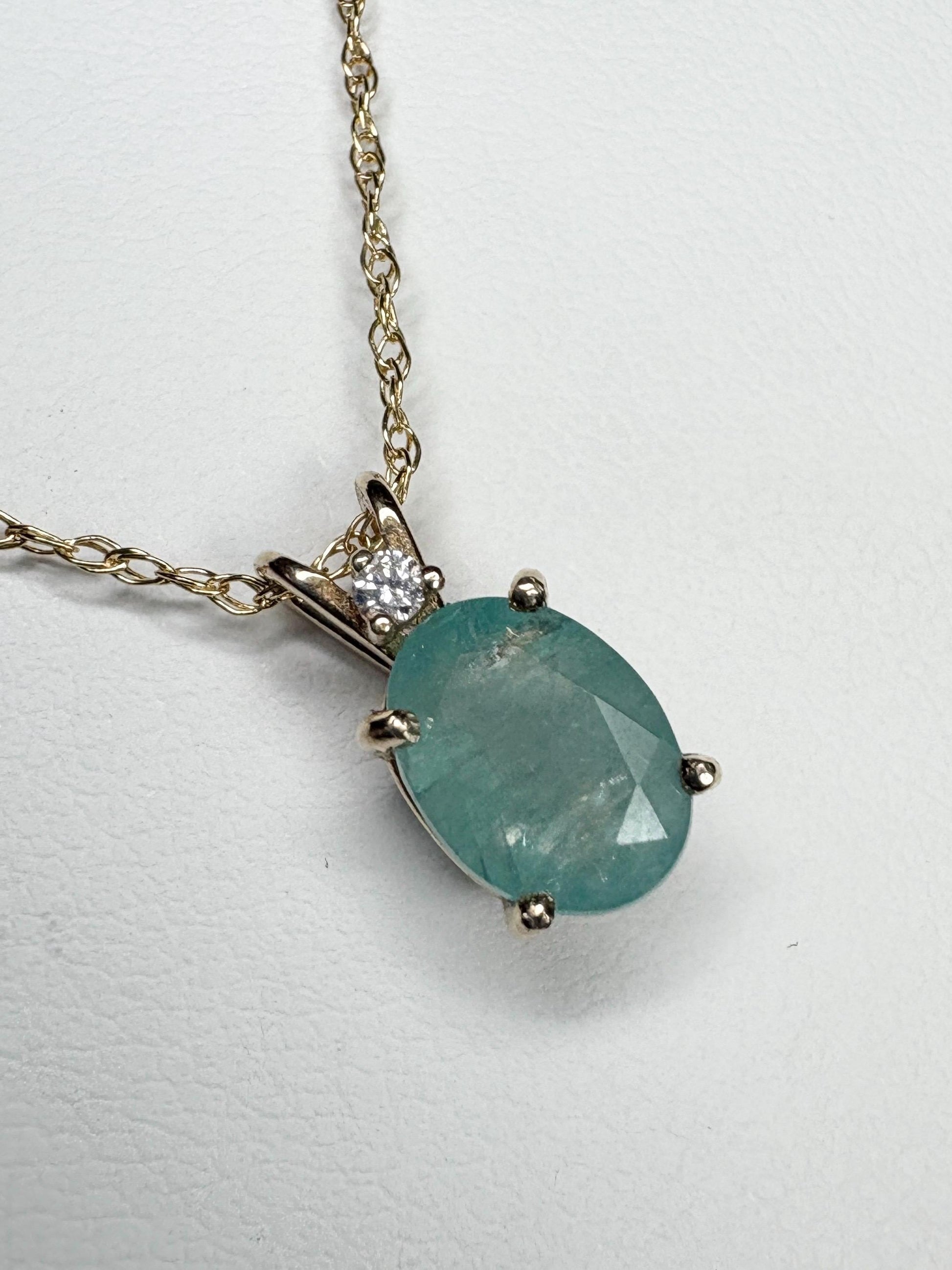 14k gold pendant necklace with oval grandidierite and diamond.