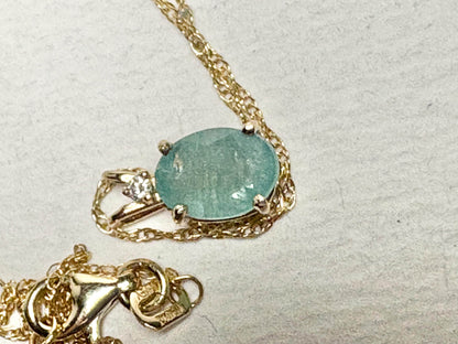 14k gold necklace with an oval grandidierite and diamond solitaire pendant.