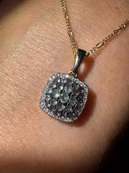 A 14k gold figaro necklace with a cushion-shaped alexandrite and diamond cluster pendant.