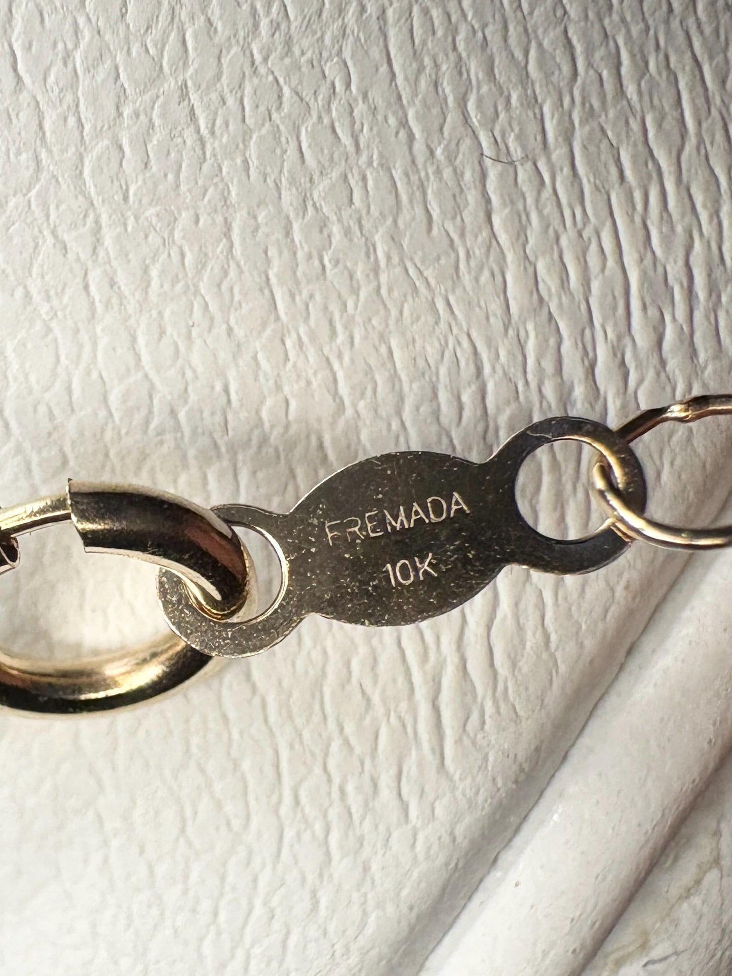 Dainty 10k gold pendant necklace with "FREMADA 10K" engraving.