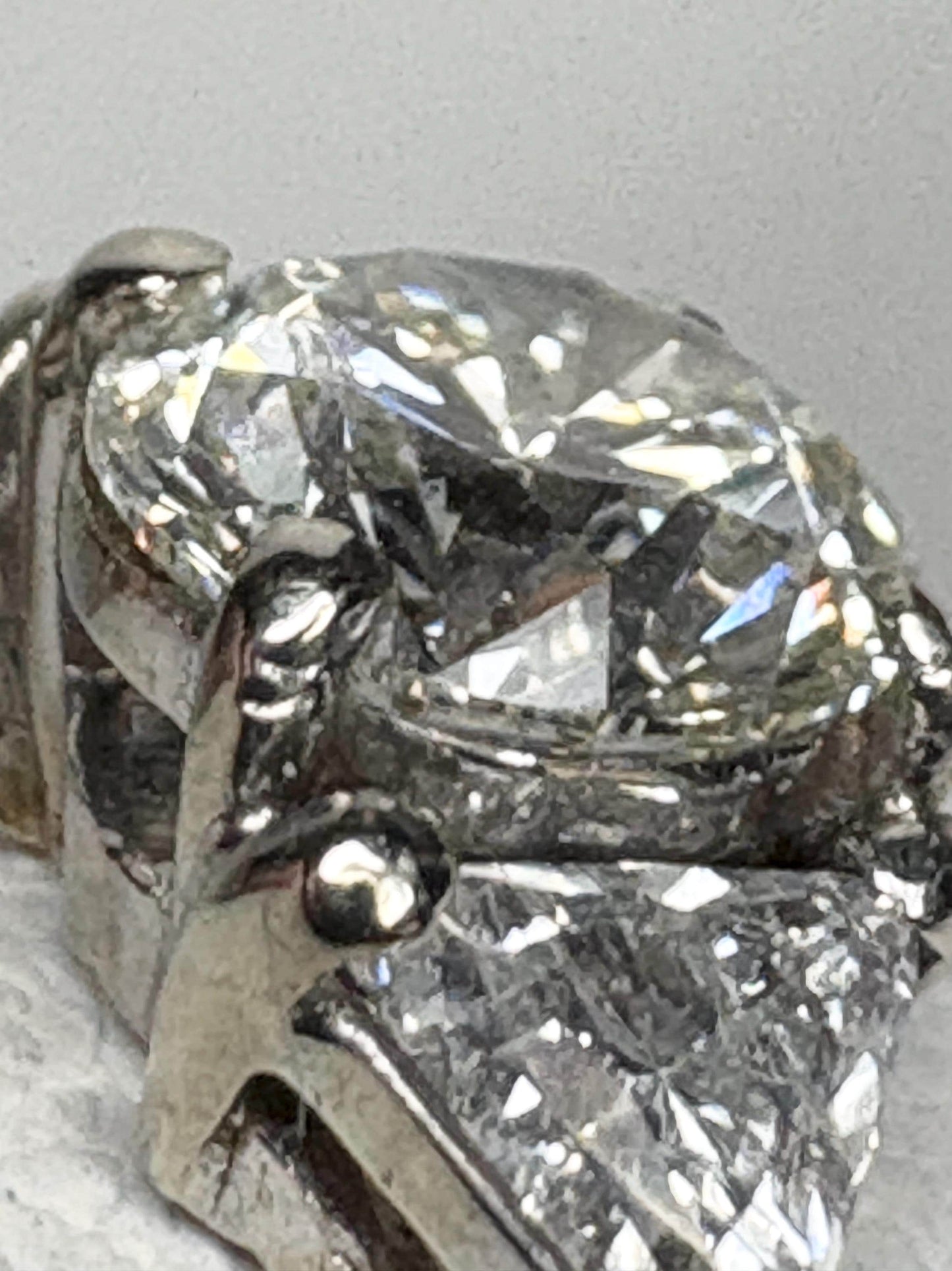 GIA certified round diamond engagement ring with trillion side stones in 18k gold.