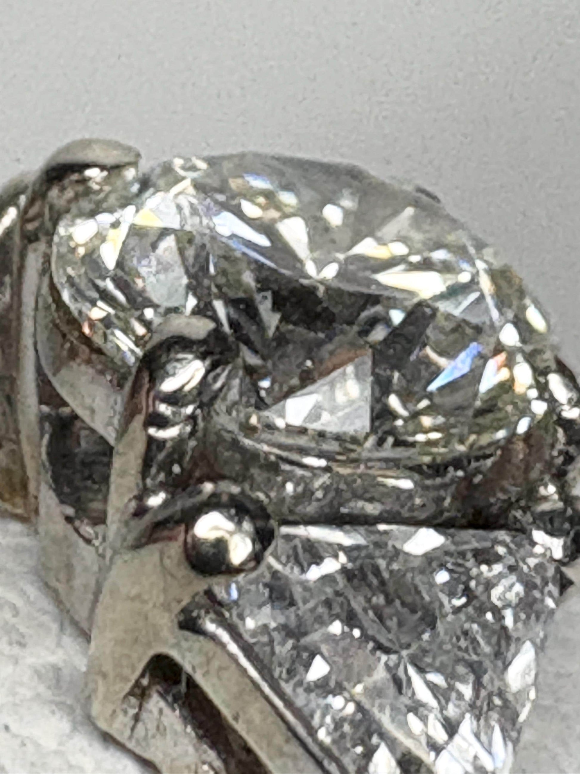 GIA certified round diamond engagement ring with trillion side stones in 18k gold.