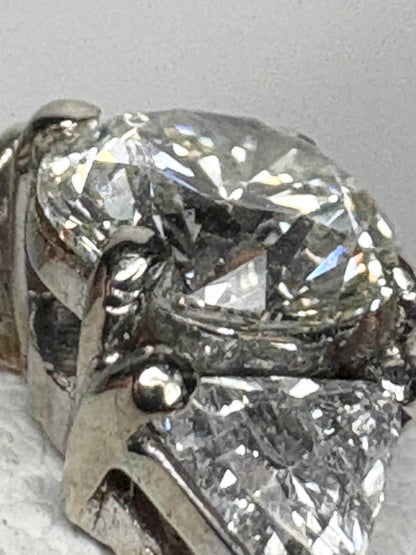 GIA certified round diamond engagement ring with trillion side stones in 18k gold.