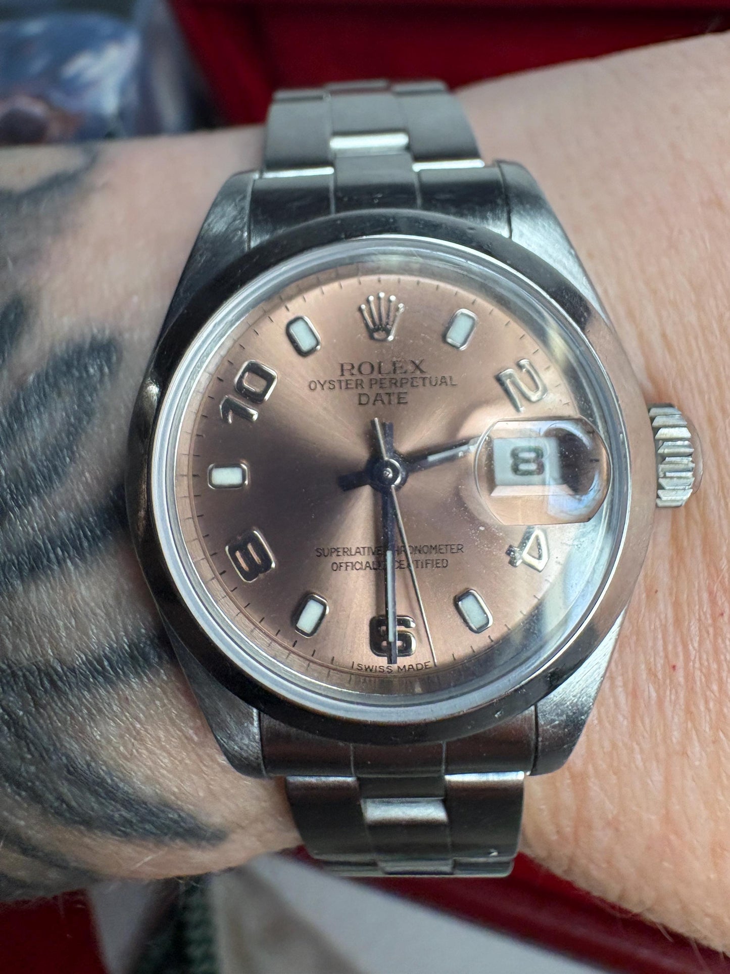 Rolex Ladies Oyster Perpetual rose dial watch with Arabic markers and date window.