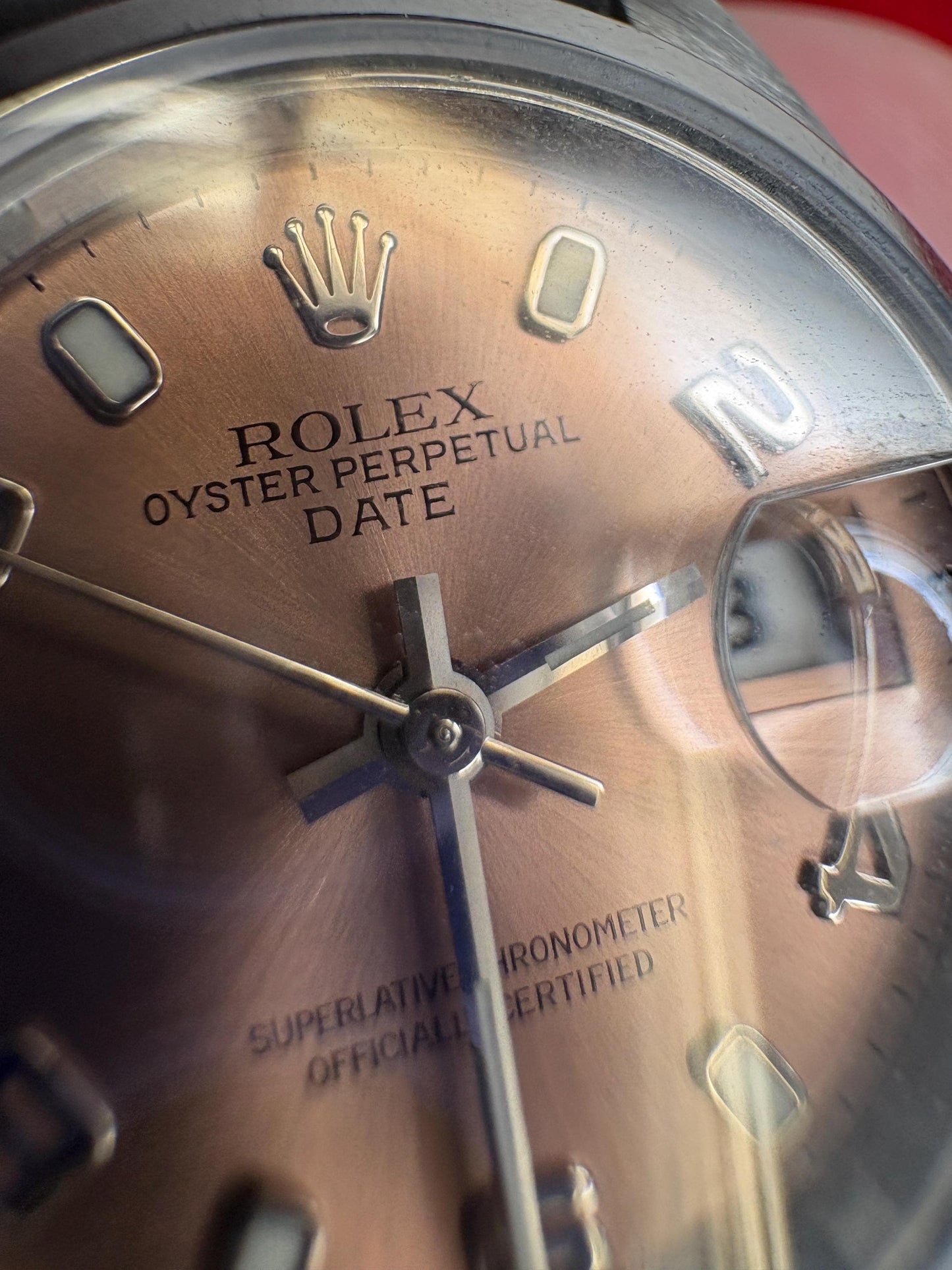 Rolex Oyster Perpetual Date rose dial automatic wristwatch with Arabic markers.