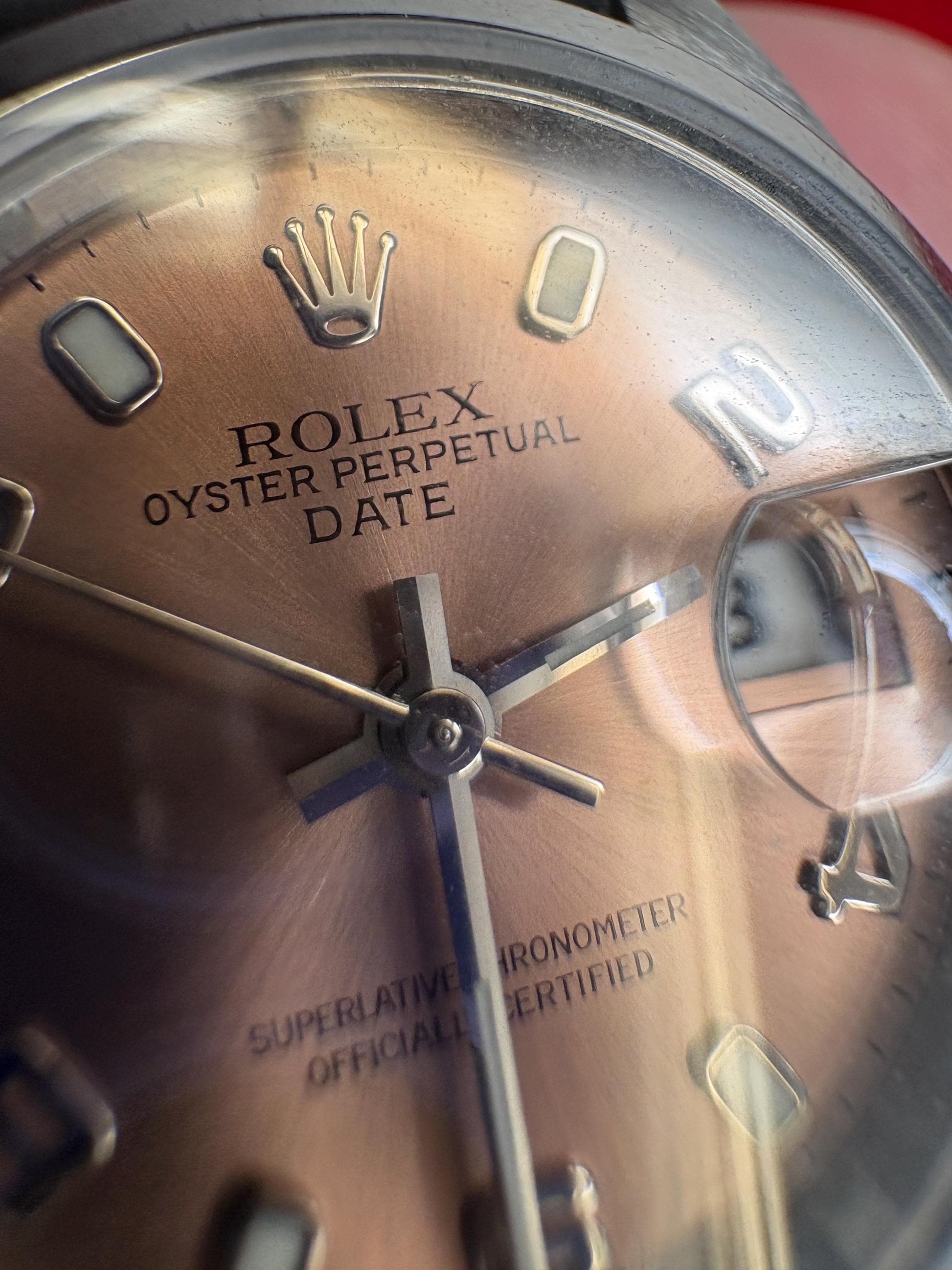 Rolex Oyster Perpetual Date rose dial automatic wristwatch with Arabic markers.