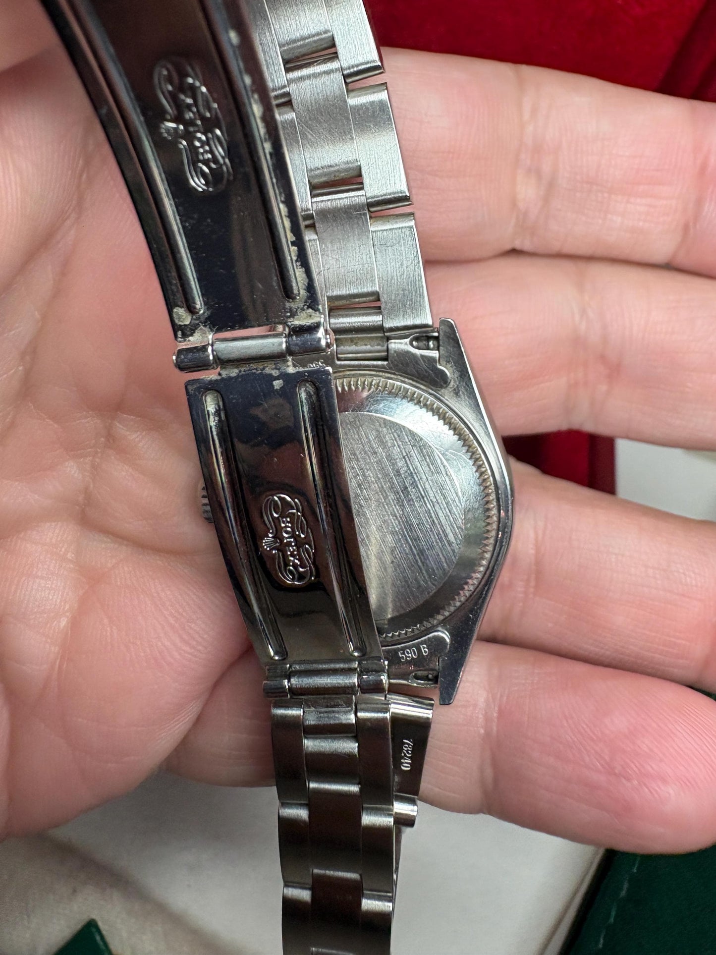 Rolex Oyster Perpetual watch with Arabic numerals and date window.