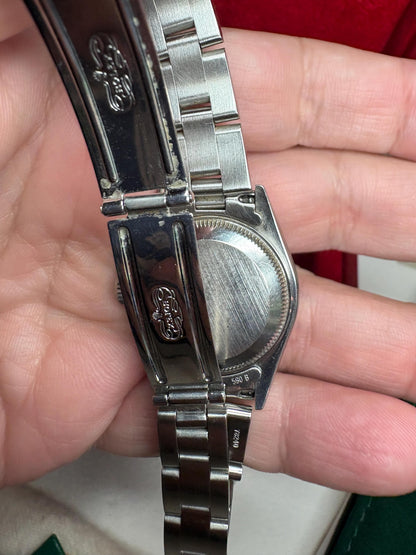 Rolex Oyster Perpetual watch with Arabic numerals and date window.