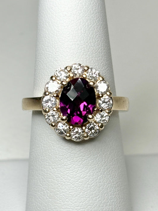 Oval checkerboard faceted rhodolite garnet ring with diamond halo in yellow gold.