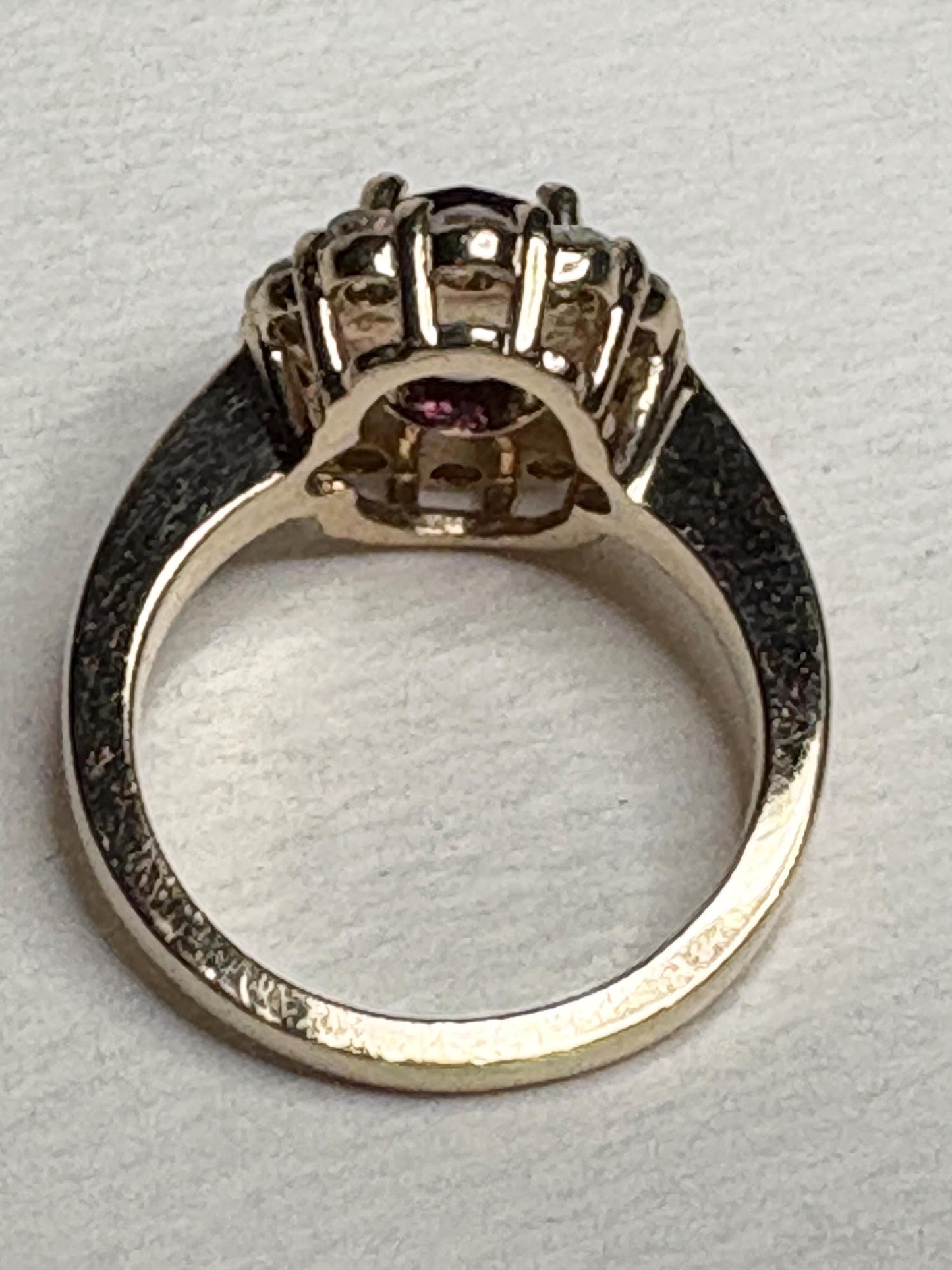 Checkerboard faceted rhodolite garnet halo ring with diamonds in 14k yellow gold.