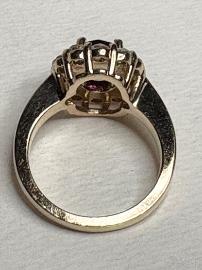 Checkerboard faceted rhodolite garnet halo ring with diamonds in 14k yellow gold.