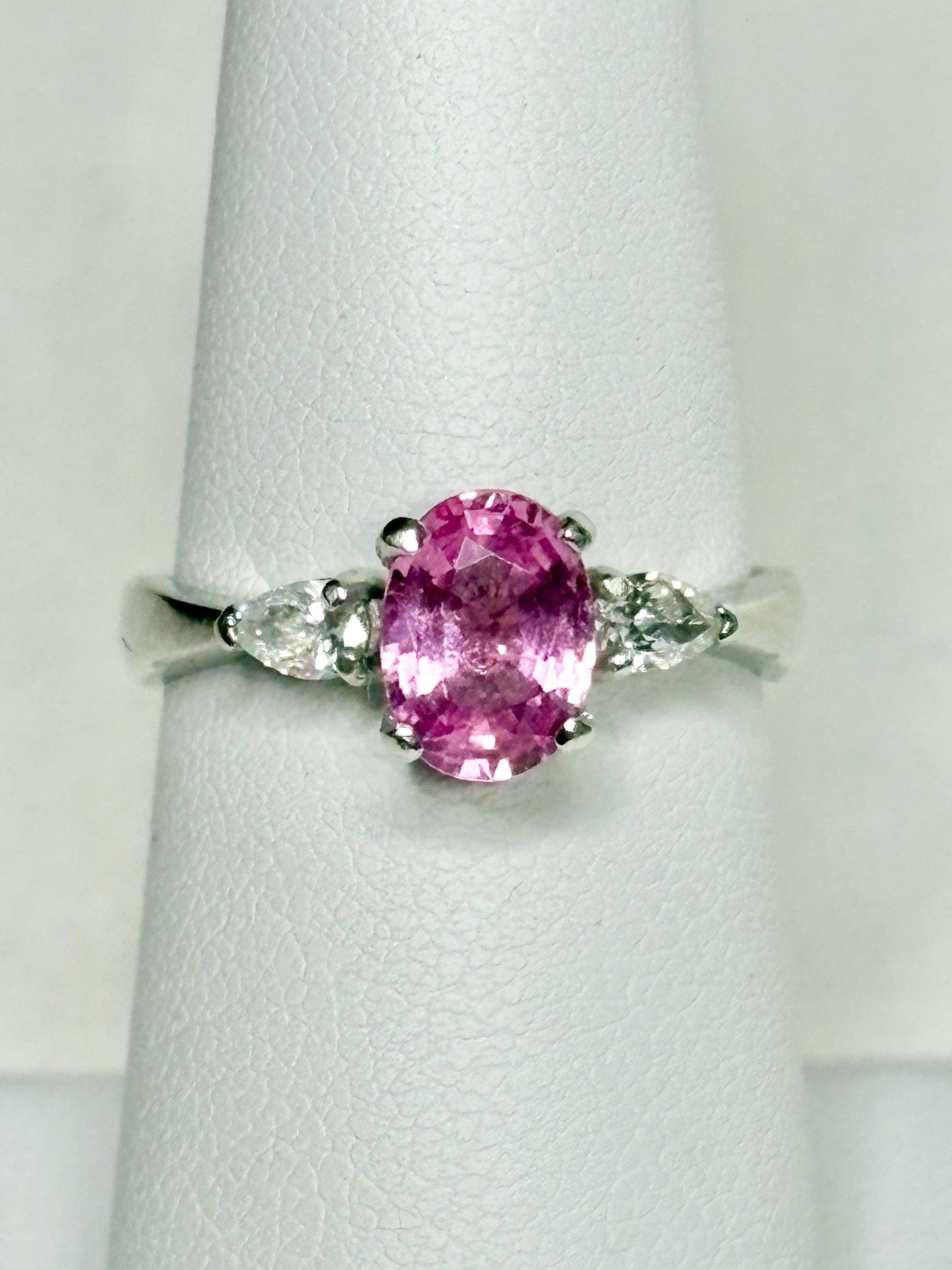 Platinum ring with oval pink sapphire and pear diamonds.