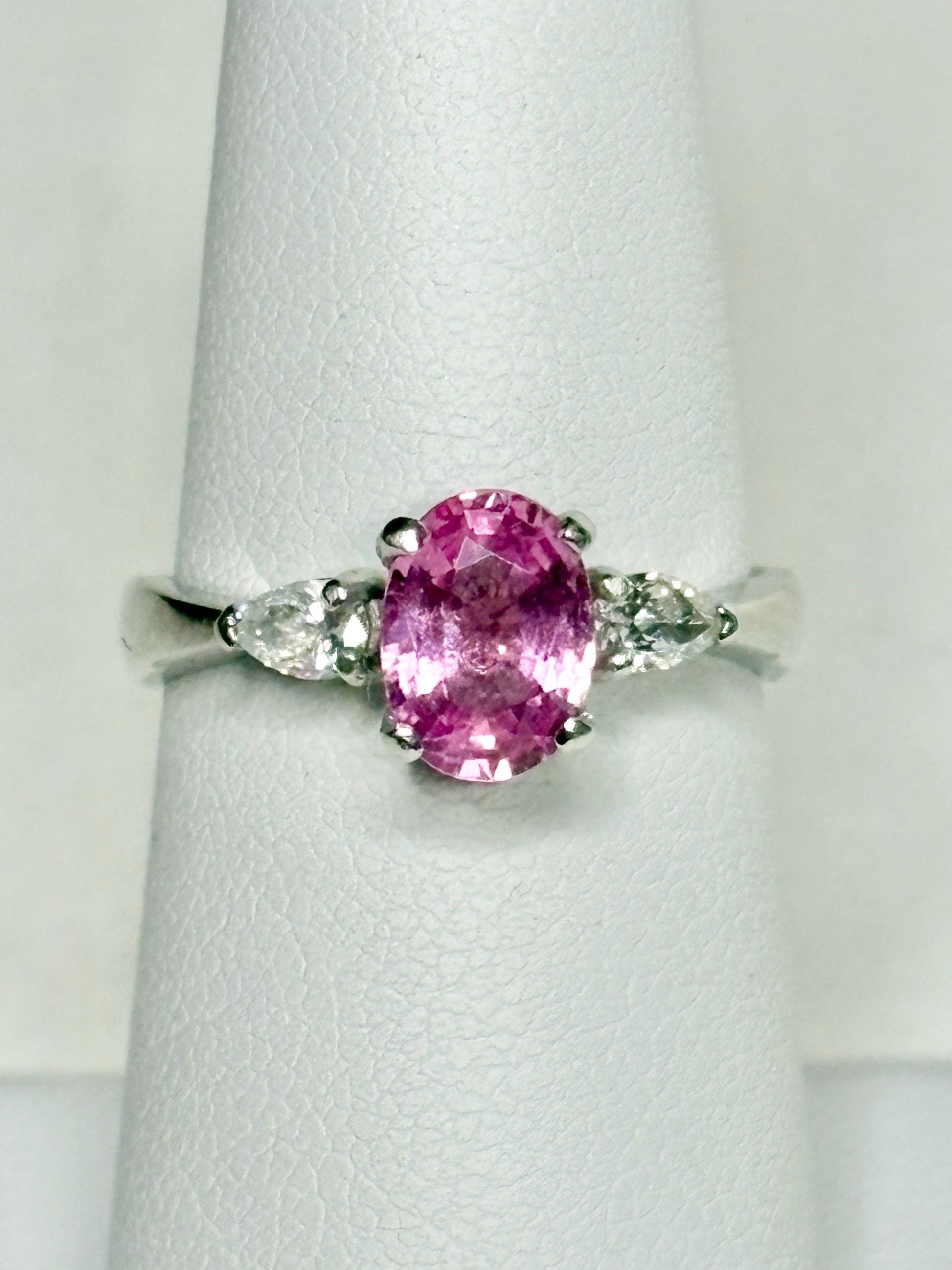 Platinum ring with oval pink sapphire and pear diamonds.