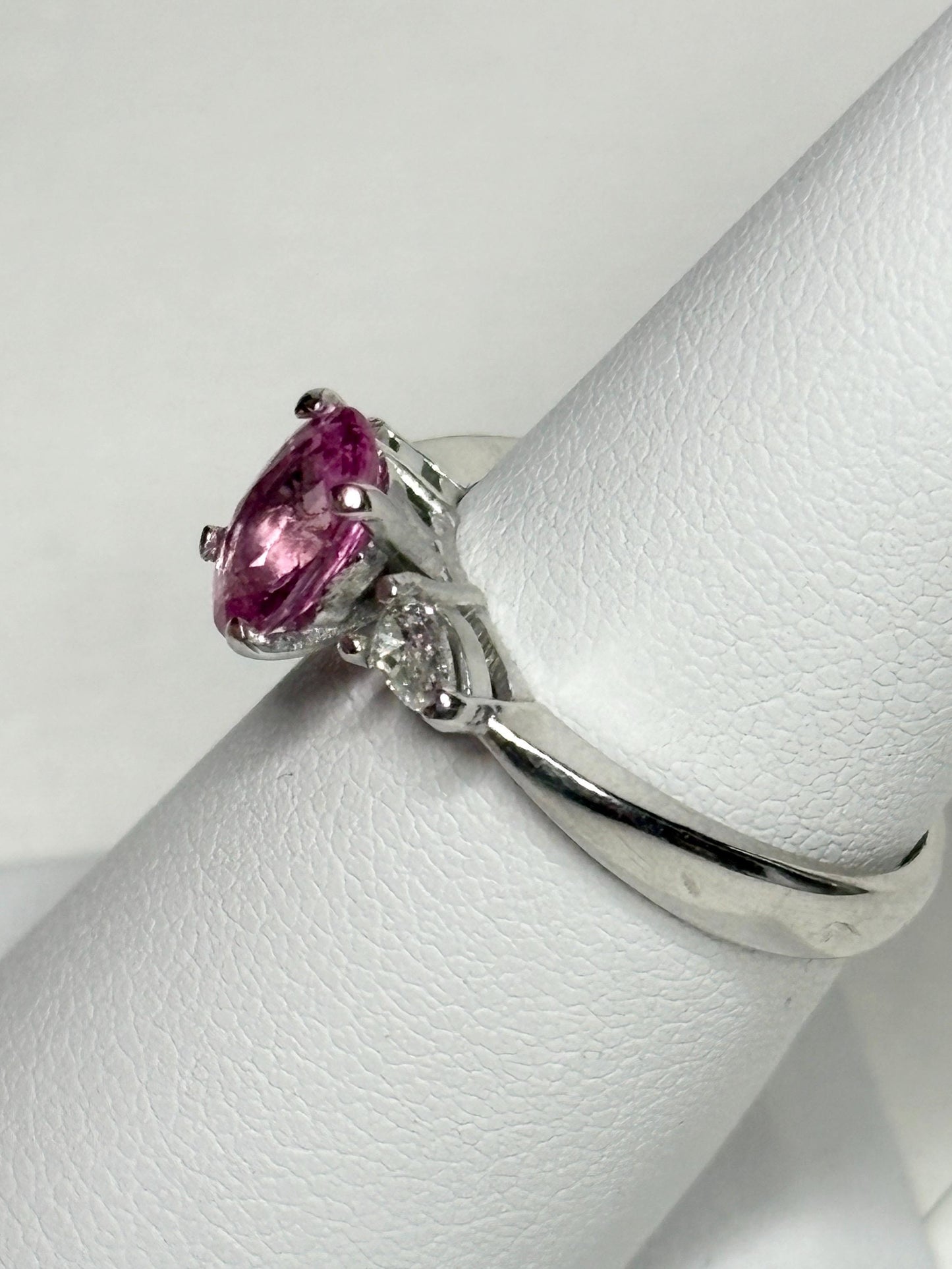 Platinum ring with oval pink sapphire and pear diamonds.