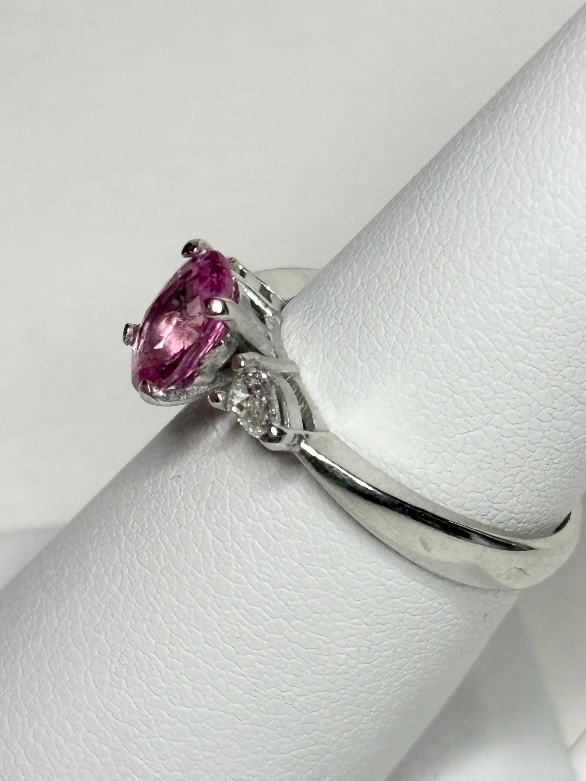 Platinum ring with oval pink sapphire and pear diamonds.