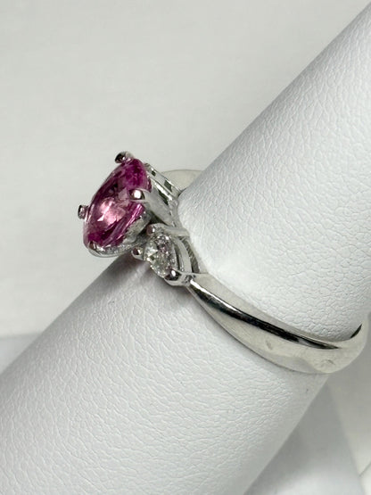 Platinum ring with oval pink sapphire and pear diamonds.