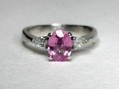 Platinum ring with oval pink sapphire and pear diamonds.