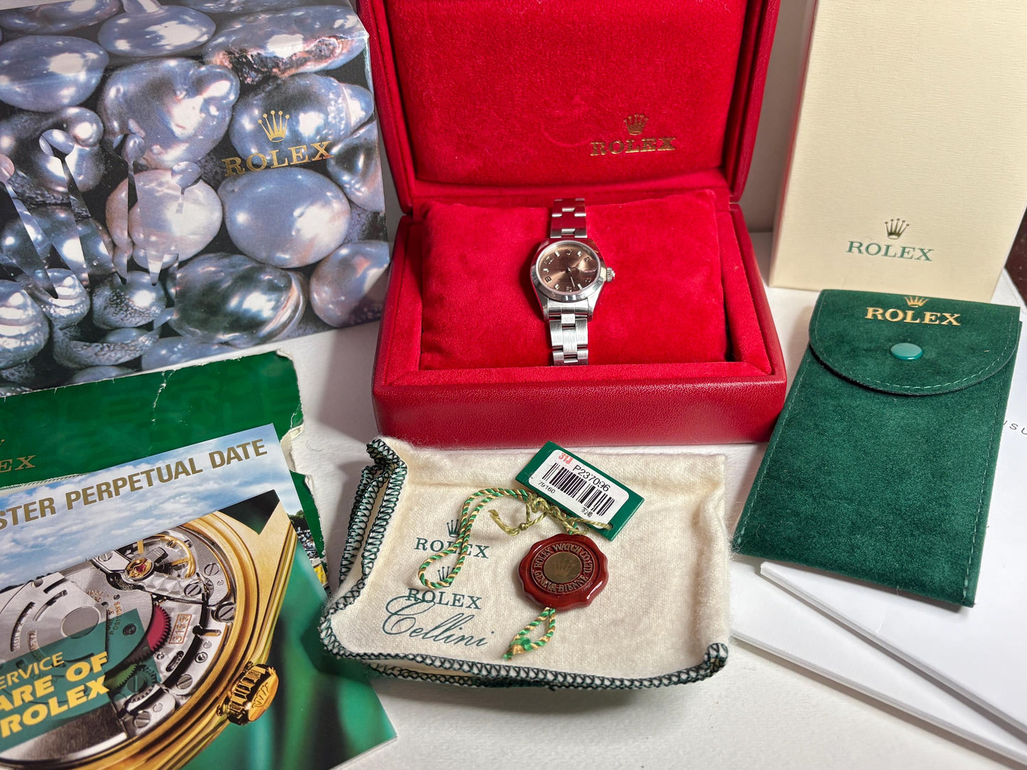 Rolex Women's Oyster Perpetual watch with rose dial, box, and papers.