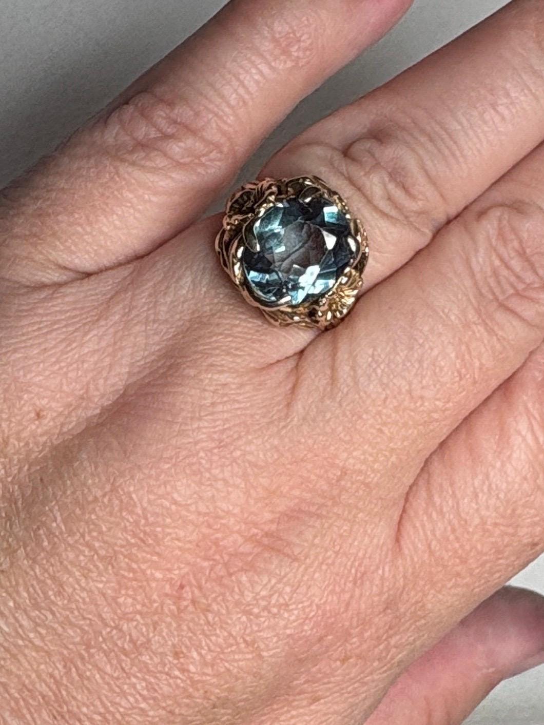 Large mid-century 10k gold ring with a blueish synthetic spinel and floral details.