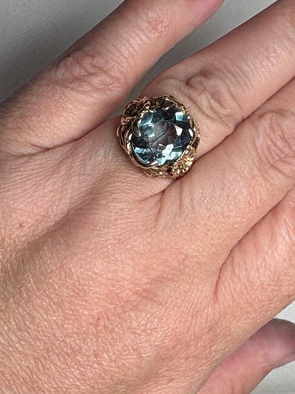 Large mid-century 10k gold ring with a blueish synthetic spinel and floral details.