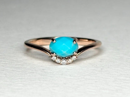 A rose gold ring with a checkerboard faceted turquoise and diamond accents.