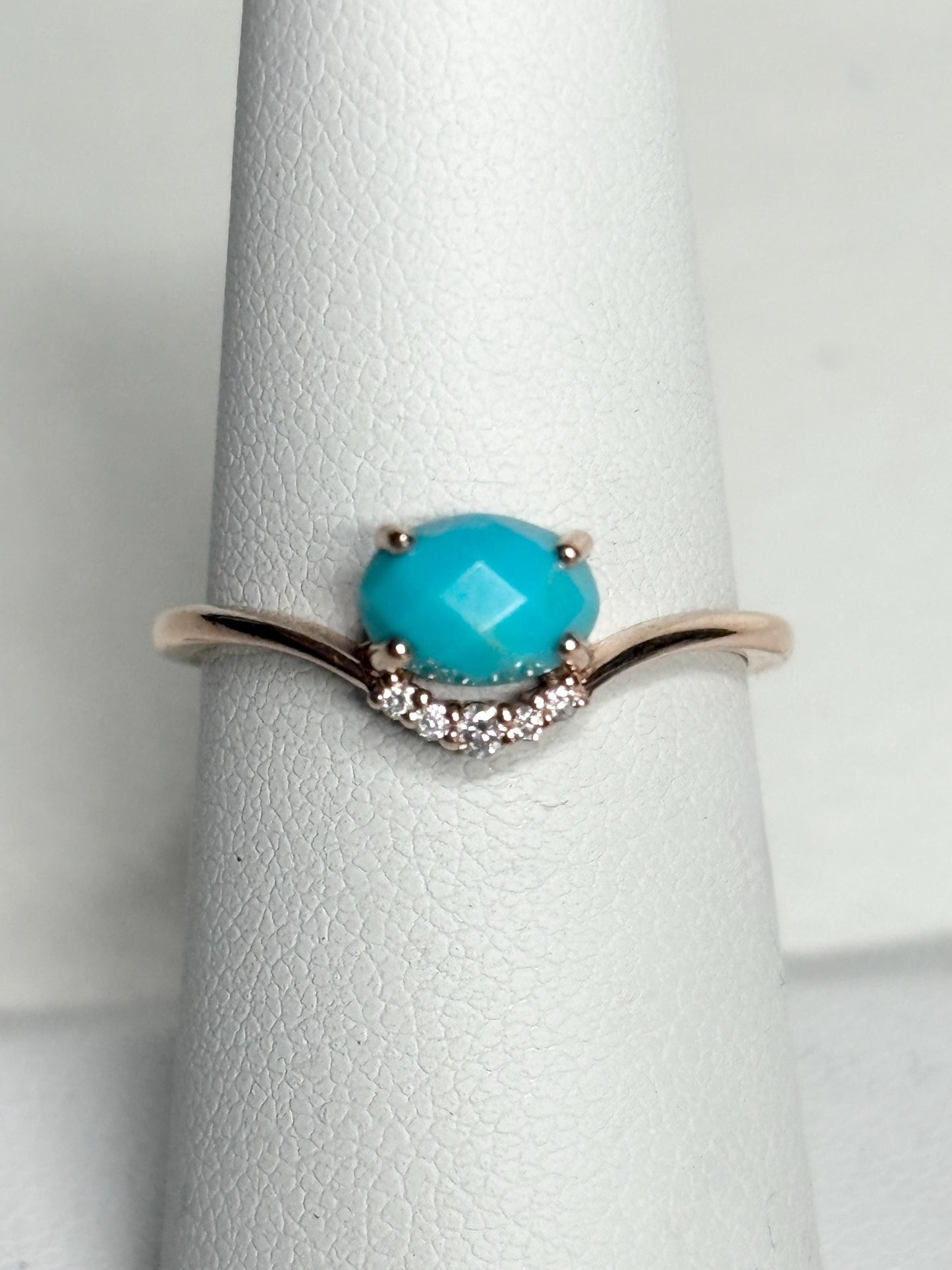 A rose gold ring with a checkerboard faceted turquoise and diamond accents.