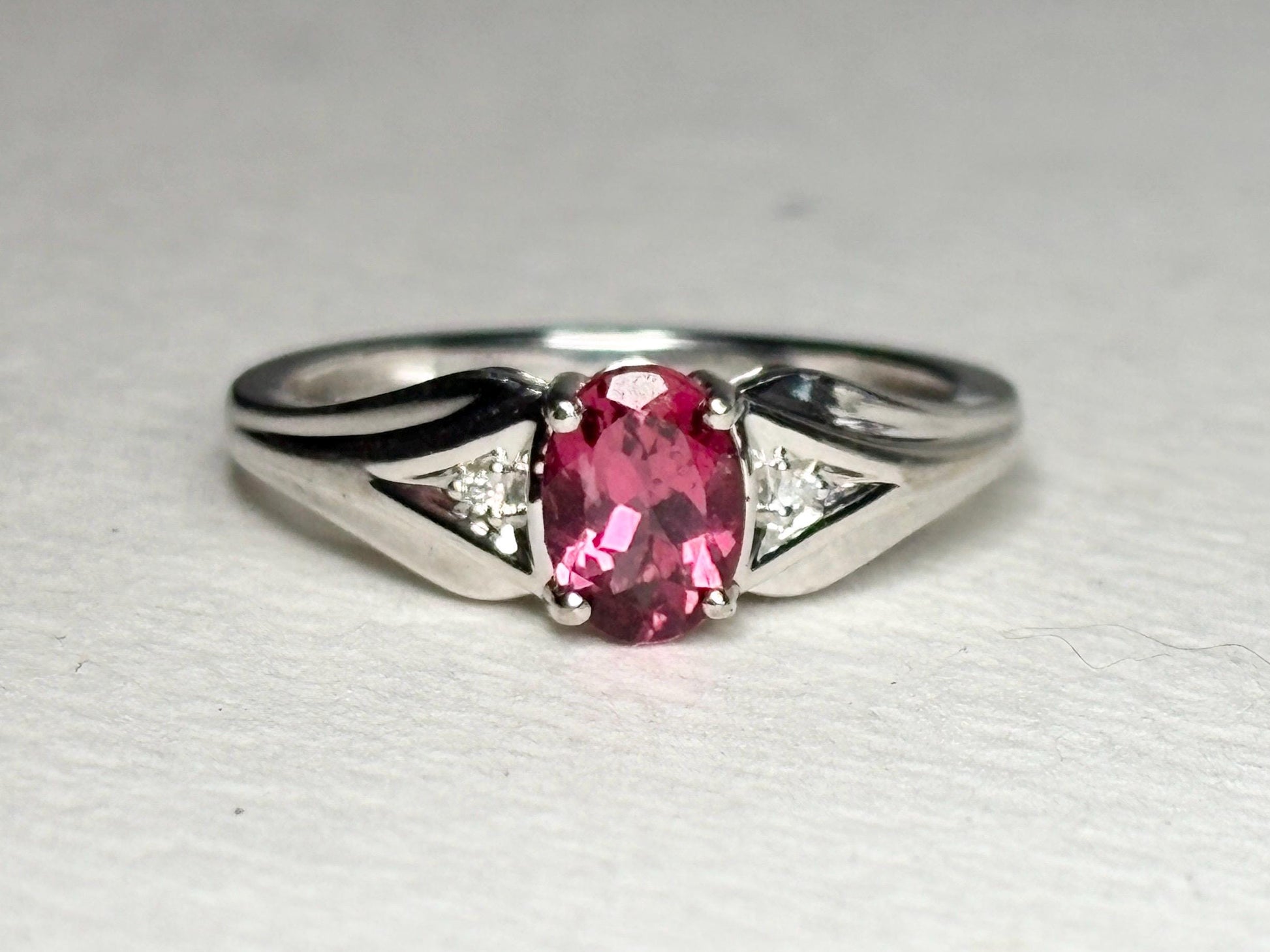 Oval pinkish red rubellite tourmaline and diamond ring in white gold.