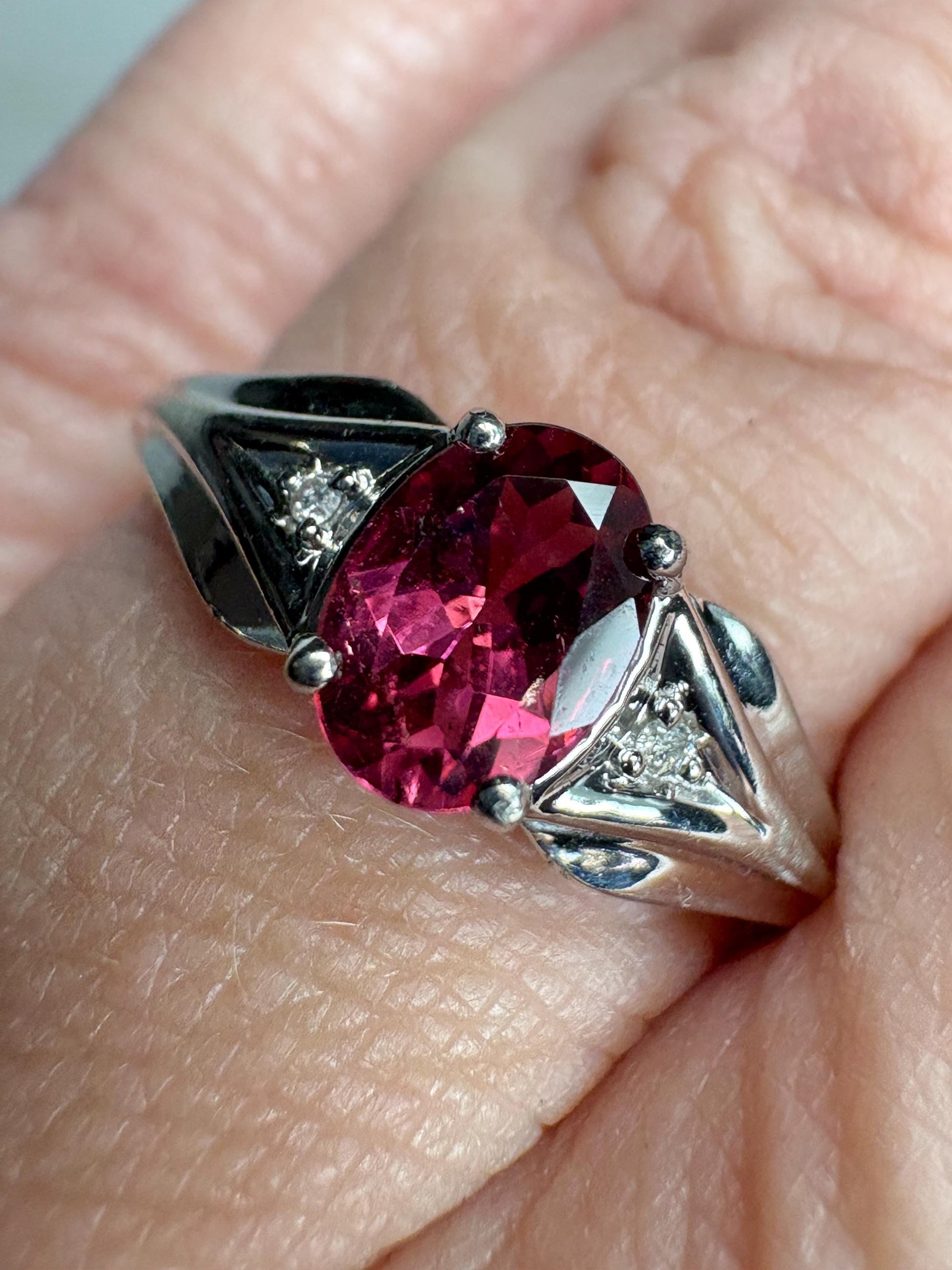 Oval pinkish red rubellite tourmaline and diamond ring in 10k white gold.