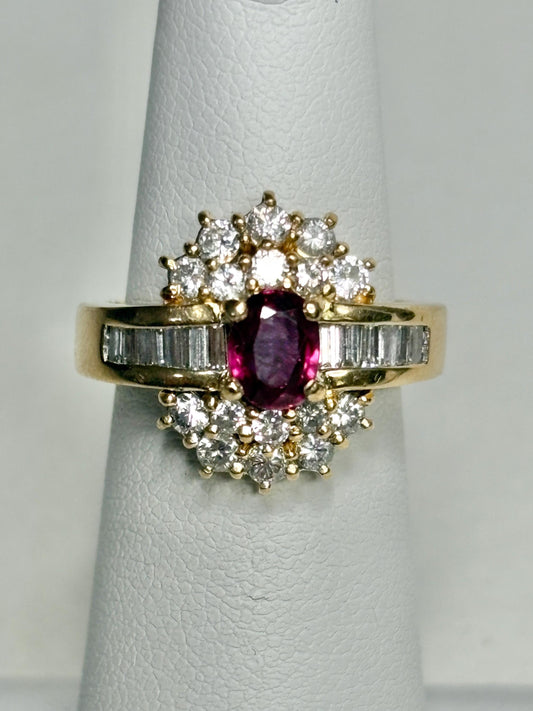 18k gold ring with oval ruby and surrounding diamonds and baguette diamonds.