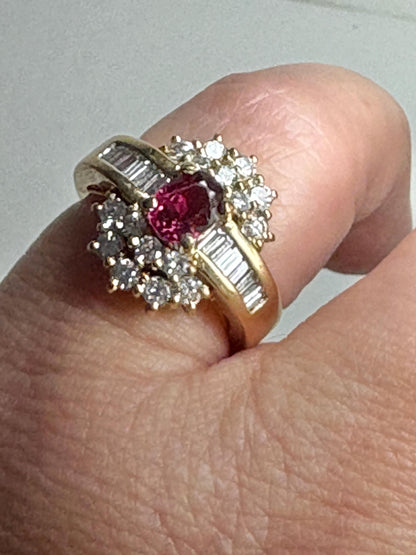 18k gold ring with a ruby center surrounded by baguette and round diamonds.