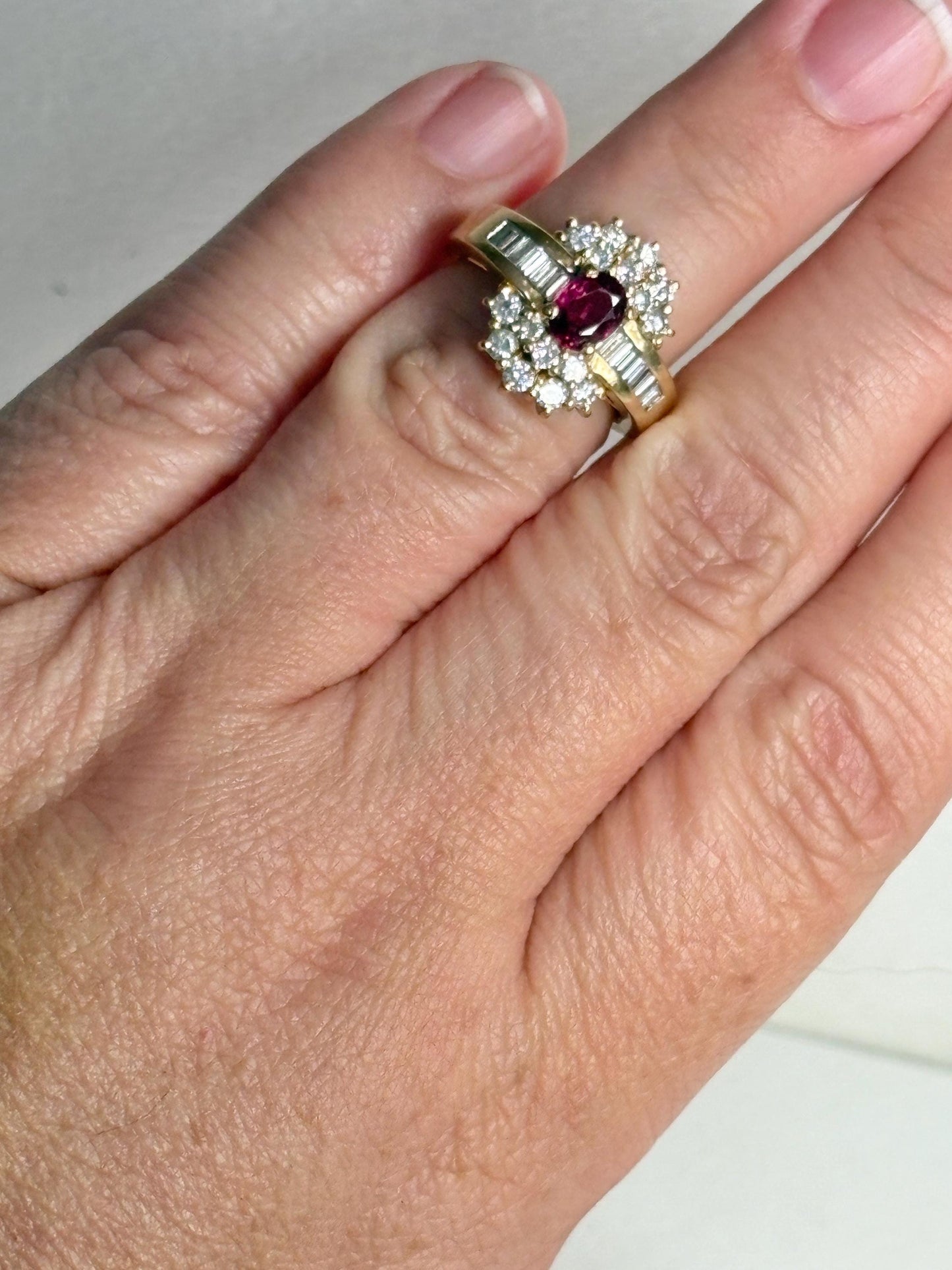 A ruby and diamond cocktail ring with baguette and round diamonds in 18k gold.