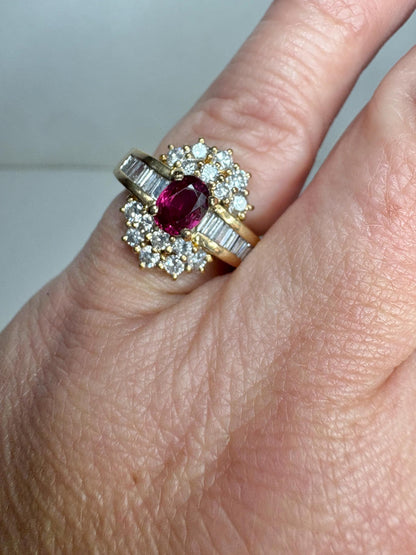 A vintage 18k gold cocktail ring with a ruby center surrounded by diamonds and baguette diamonds.