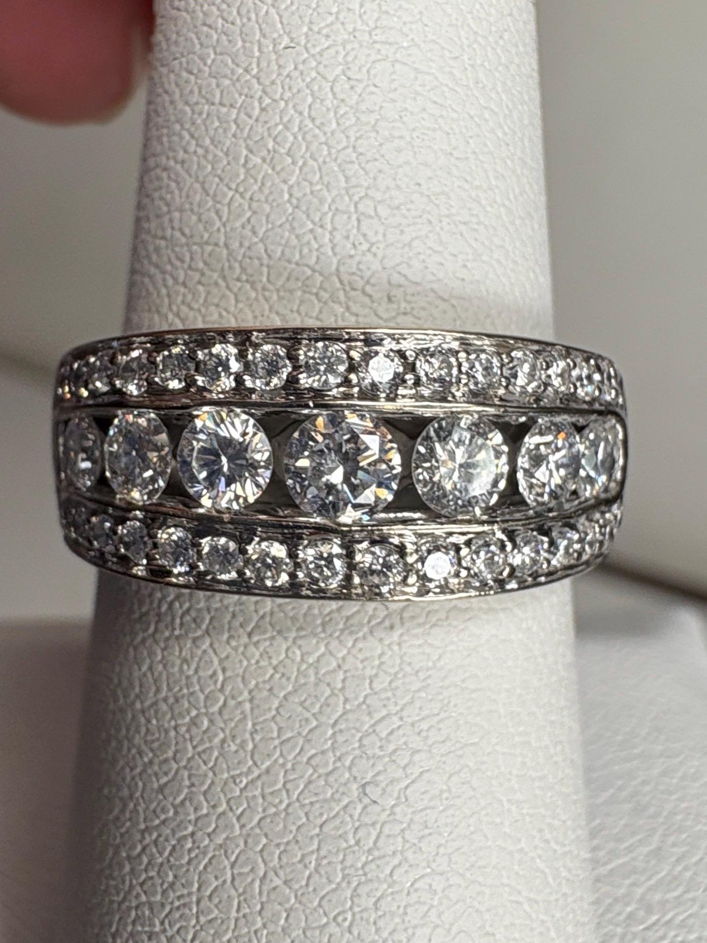 A 14k white gold anniversary band ring with channel and pave set diamonds.