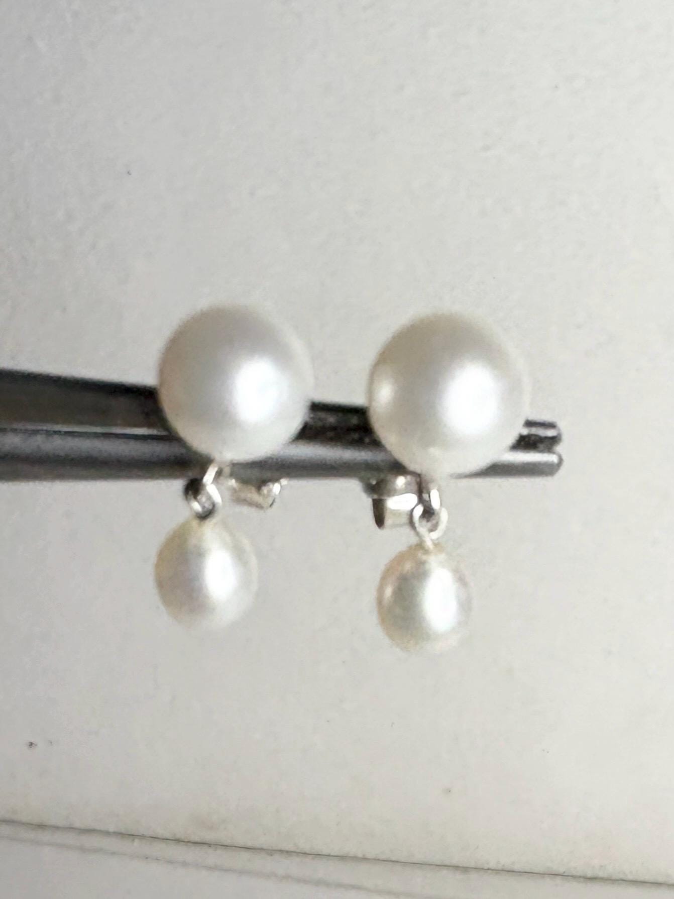Sterling silver dangle earrings with two freshwater cultured pearls.
