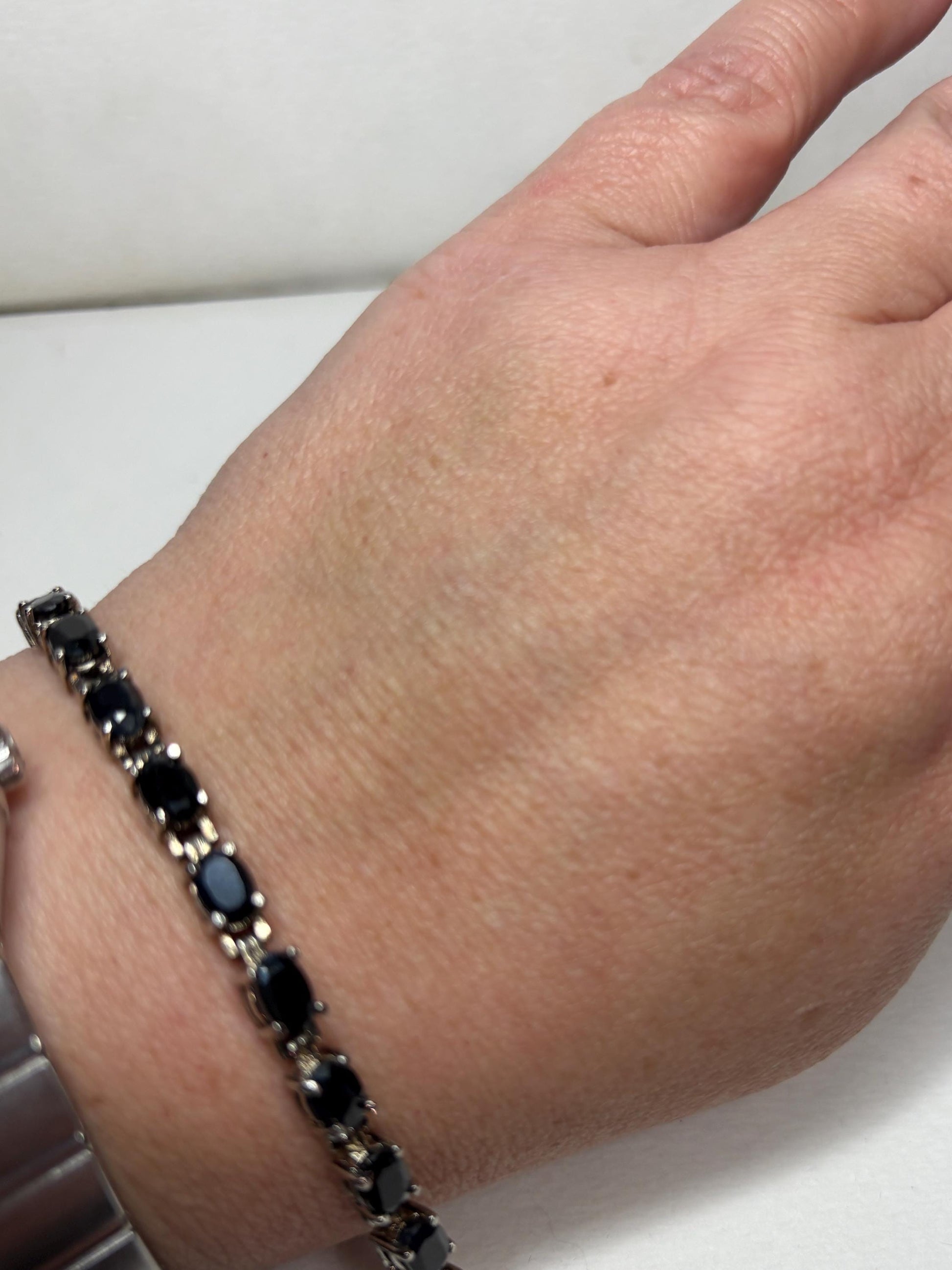 Bracelet with oval dark blue sapphires in stainless steel and sterling silver.