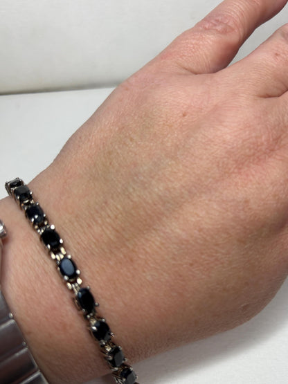 Bracelet with oval dark blue sapphires in stainless steel and sterling silver.