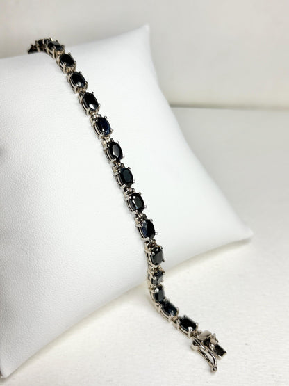Oval dark blue sapphire tennis bracelet in stainless steel with sterling silver.