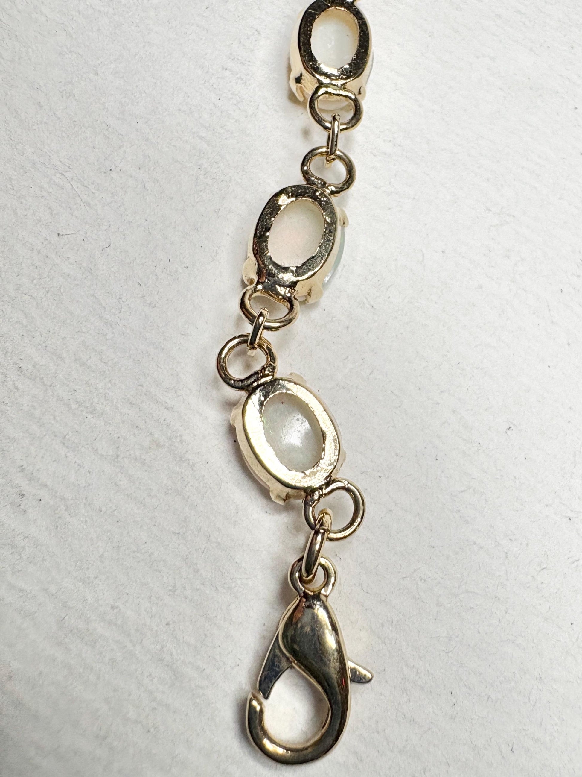 Gold plated bracelet with oval opal stones and a lobster clasp.