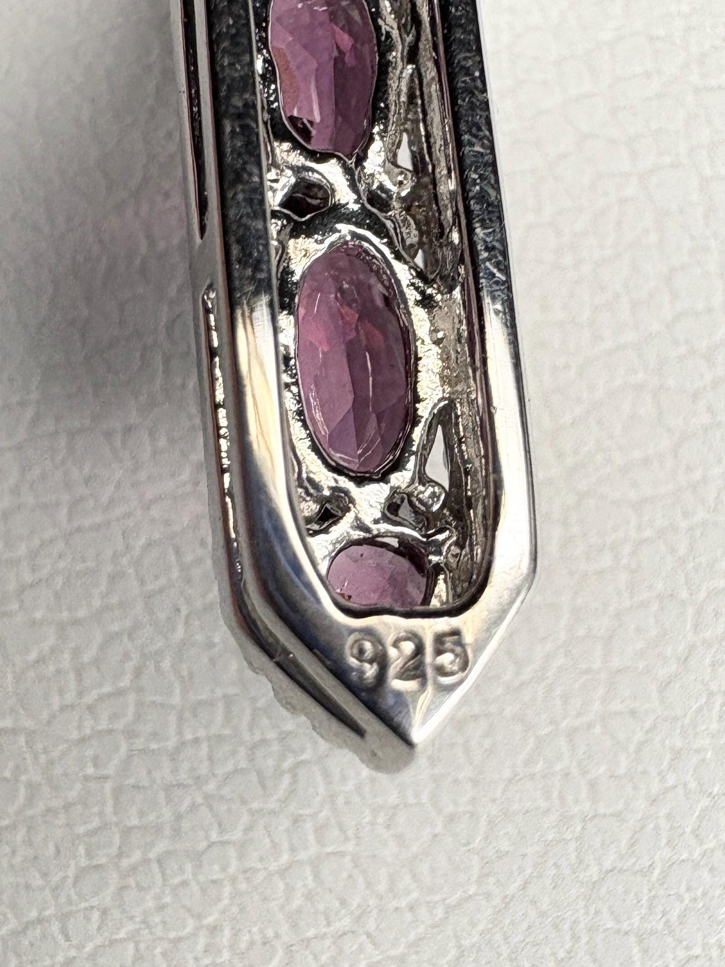 Sterling silver pendant with rhodolite garnets and "925" stamp.