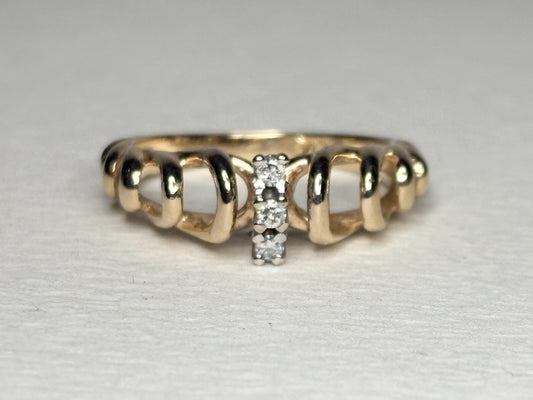 Vintage 14k gold band ring with ribbon loops and three small diamonds.