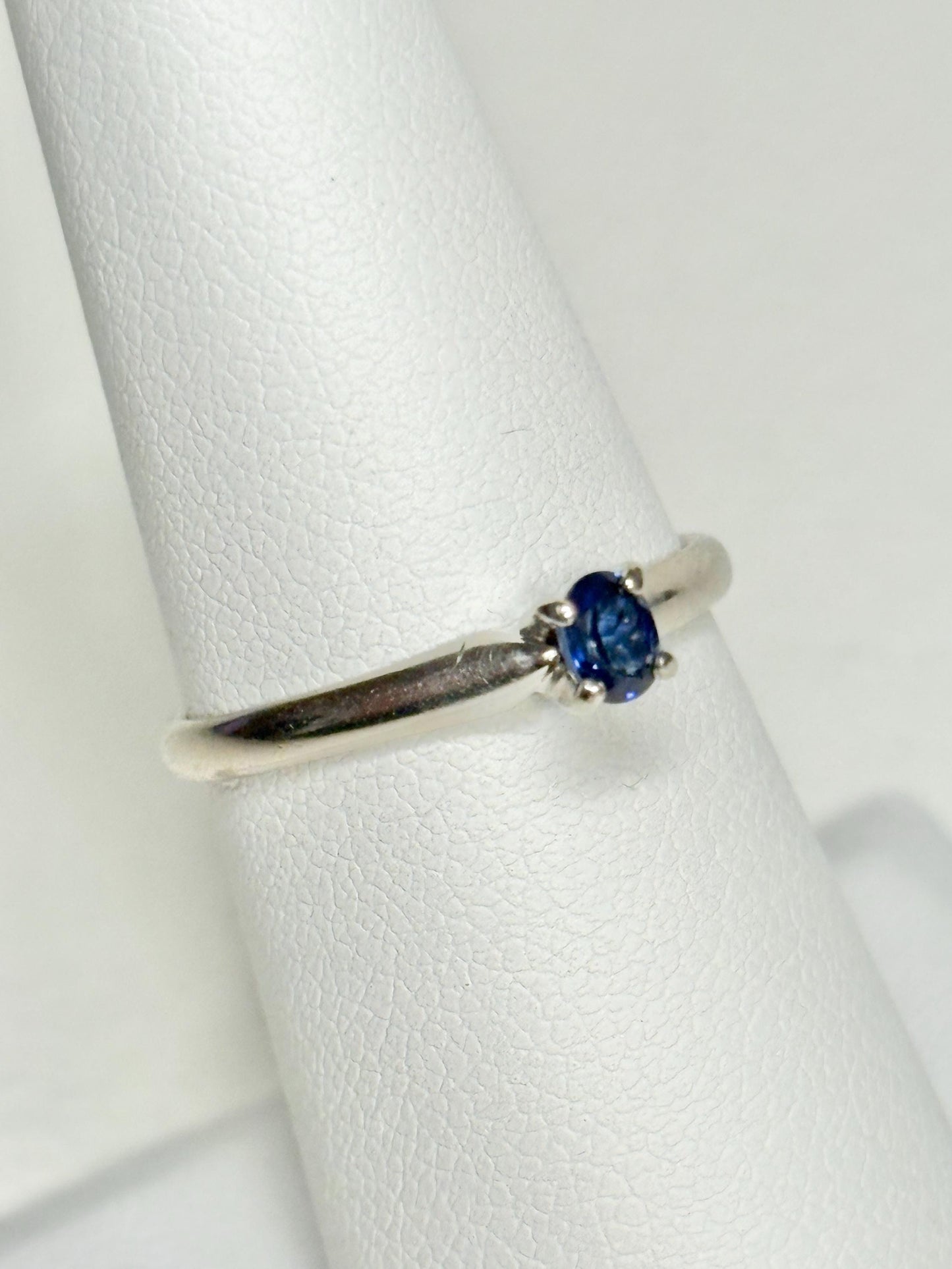 Oval violetish blue sapphire solitaire ring in 14k white gold.