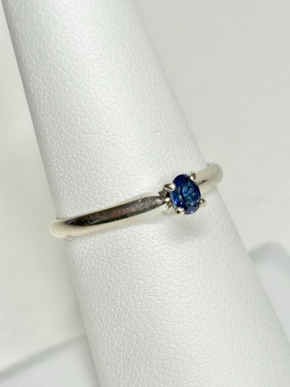 Oval violetish blue sapphire solitaire ring in 14k white gold.