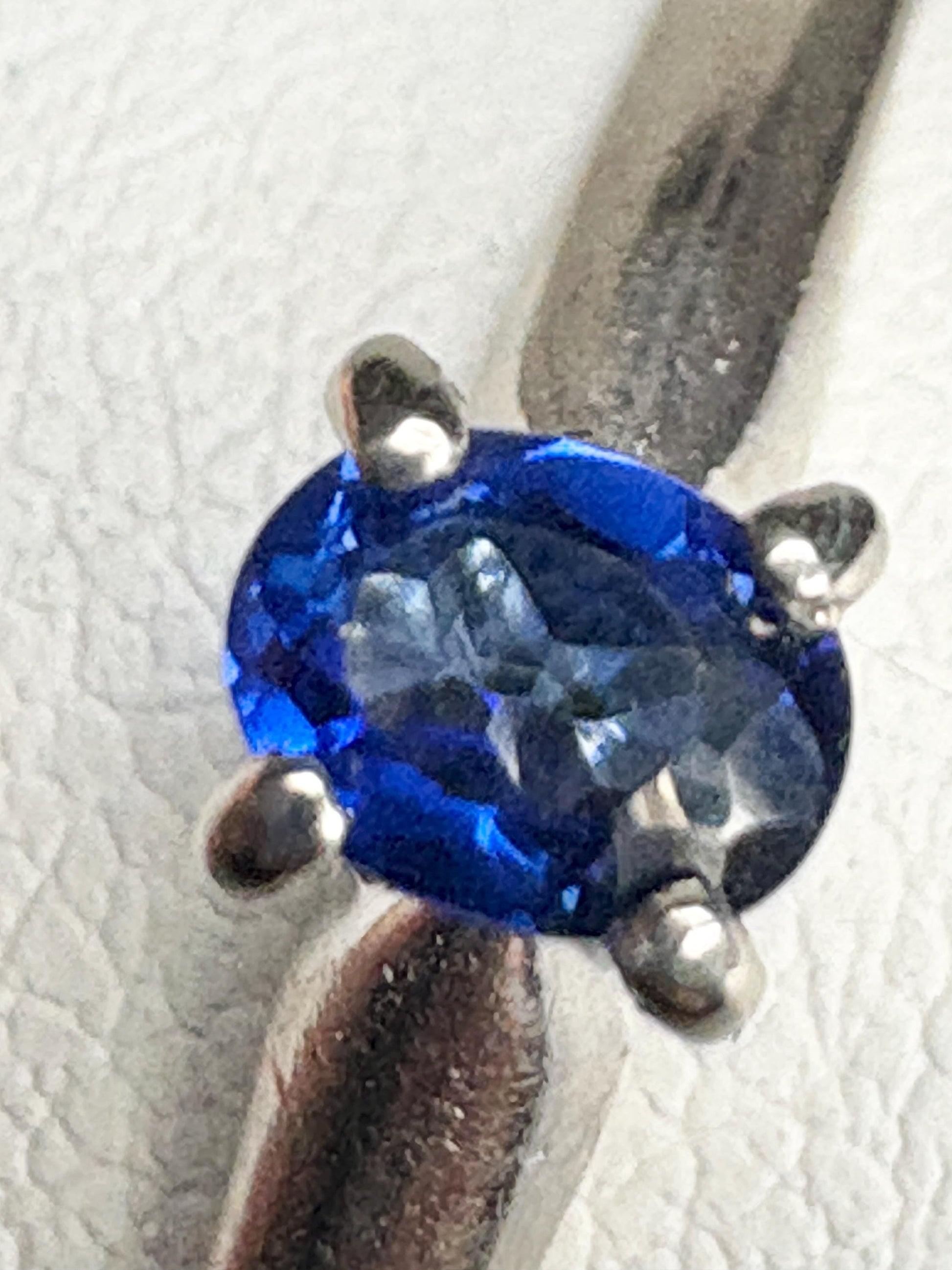 Vivid violetish blue oval sapphire solitaire in solid 14k white gold.