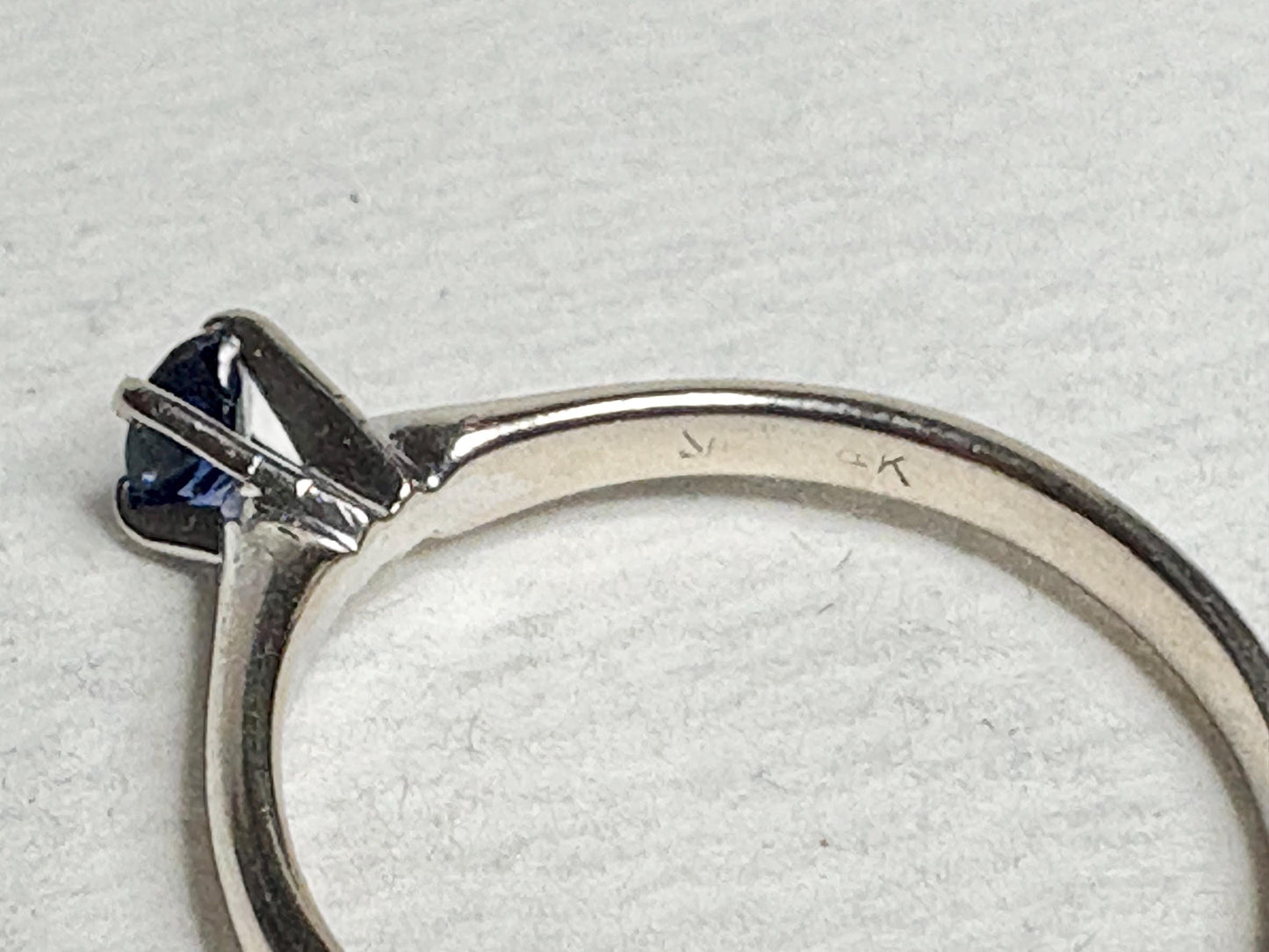 A vivid violetish blue sapphire solitaire ring in solid 14k white gold.