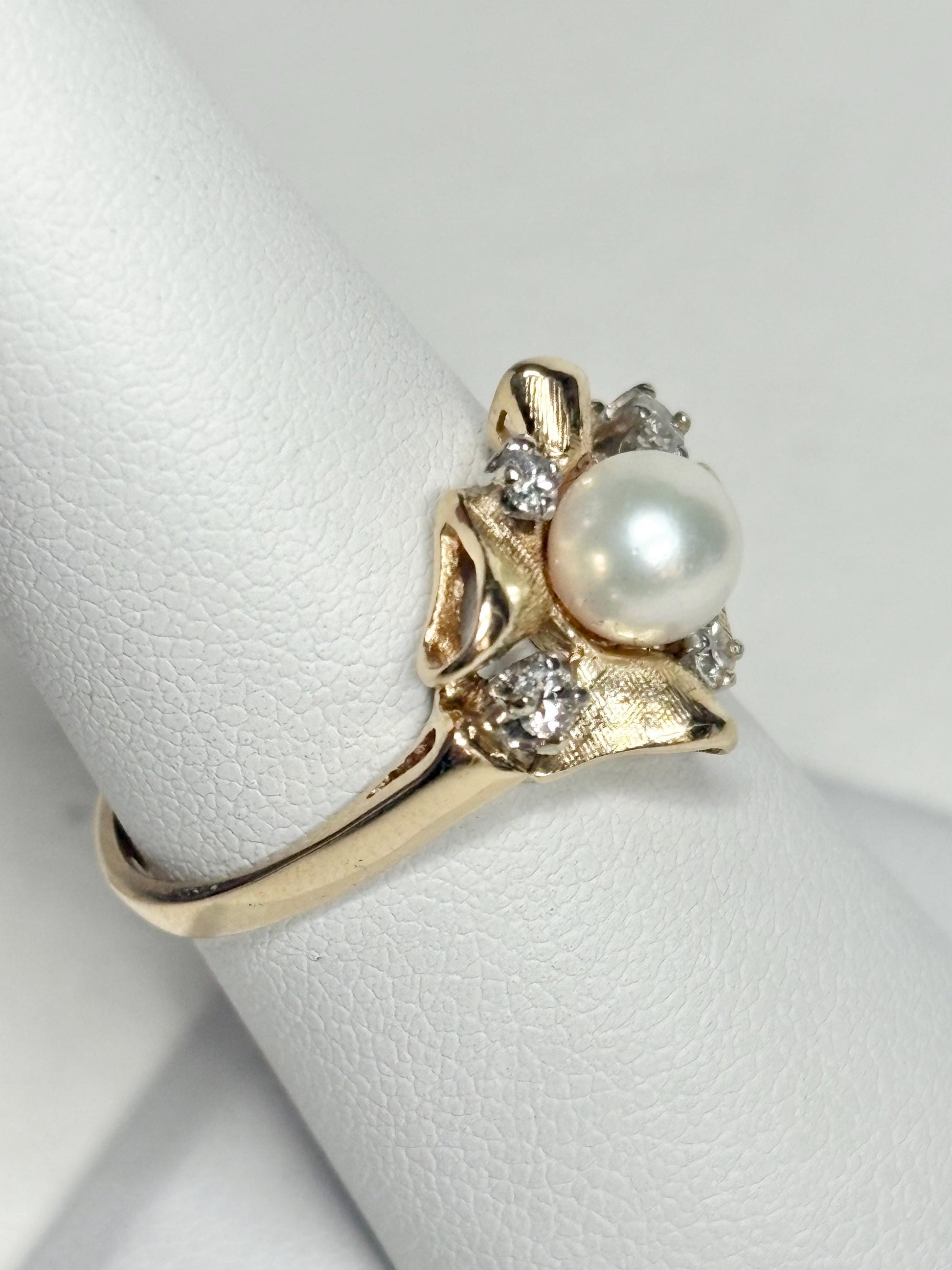 14k gold ring with Akoya pearl and diamonds in a bow design.