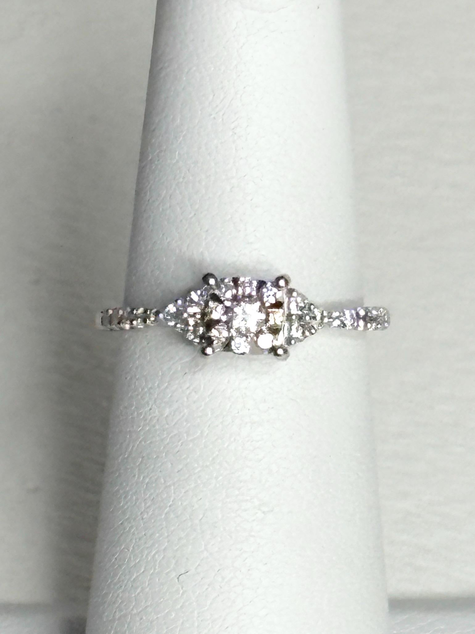 A 14k white gold ring with a squared diamond halo cluster.