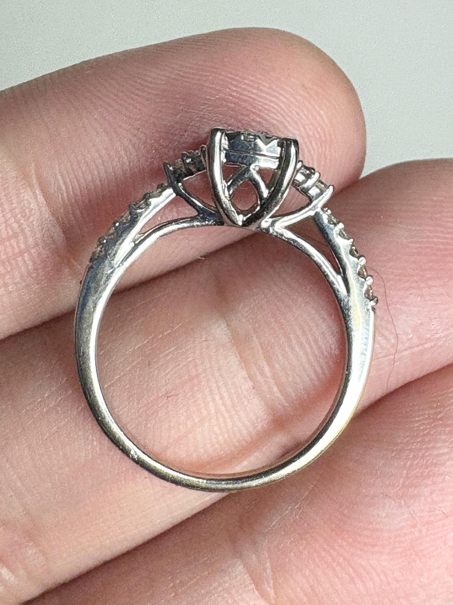 A 14k white gold engagement ring with a squared diamond halo cluster.